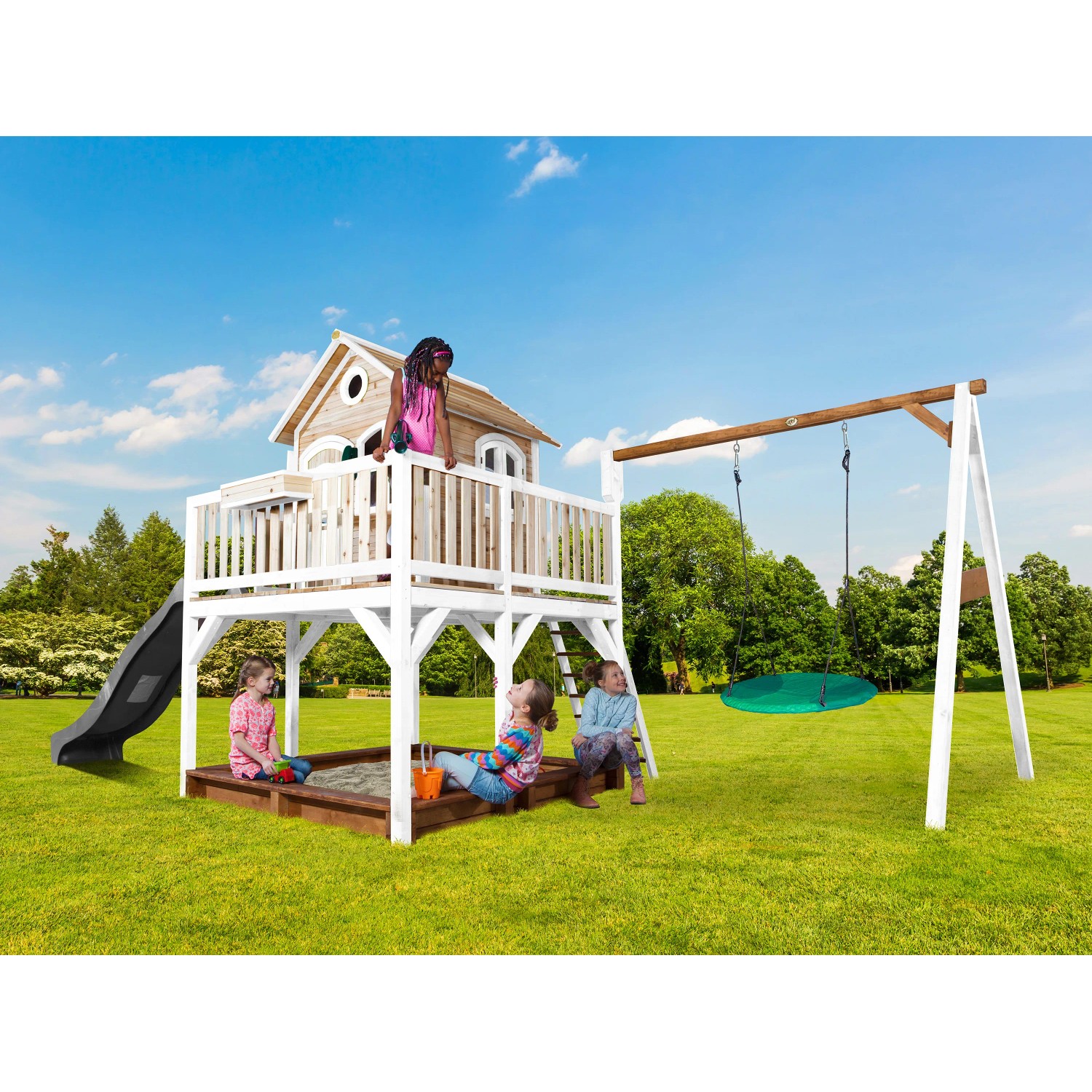 Axi Liam Spielhaus mit Nestschaukel, Rutsche und Sandkasten im Garten.