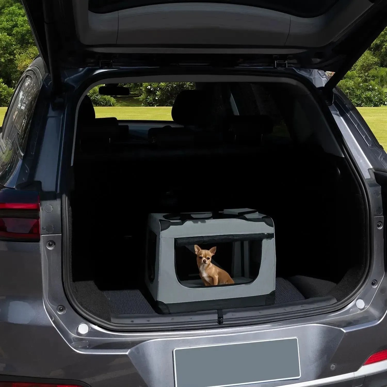 Graue Juskys Hundetransportbox Lassie S im Kofferraum mit kleinem Hund.