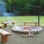 Dunkle Dansand Gartenweg Wegedecke um Feuerstelle mit Bänken im Garten.