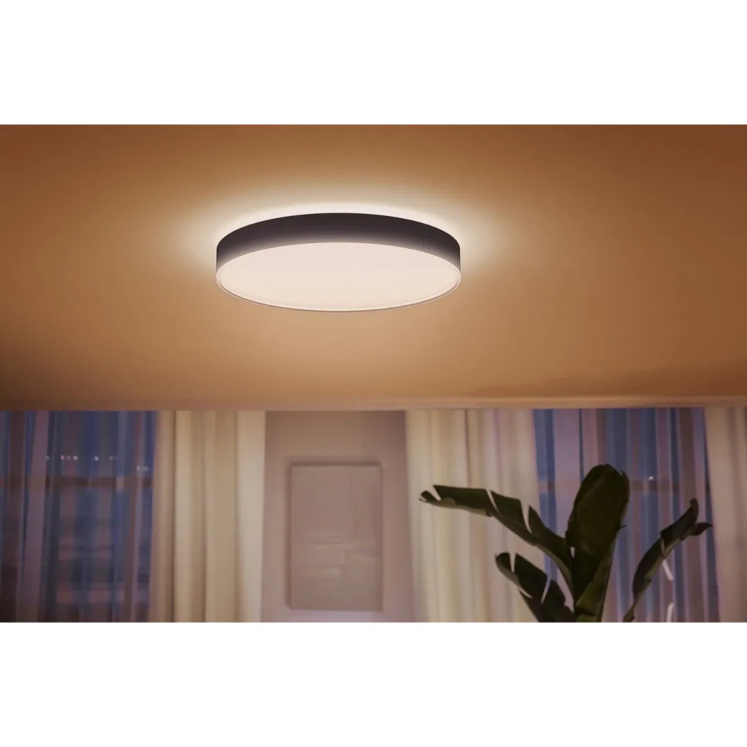 Schwarze Philips Hue Enrave XL Deckenleuchte mit warmweißem Licht, montiert an der Decke.