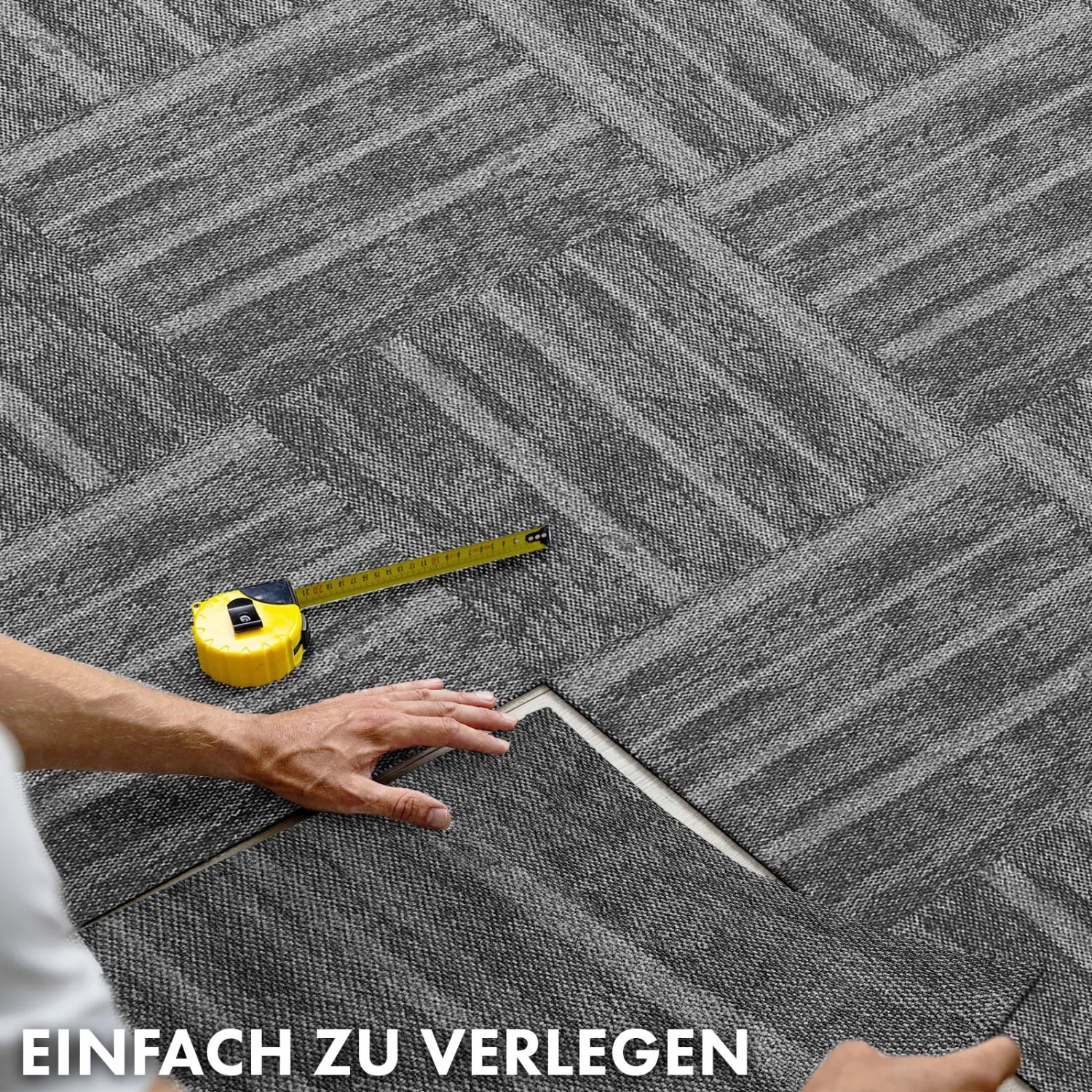 Verlegen von anthrazitfarbenen Floordirekt Teppichfliesen Zürich (50x50 cm) mit Muster.