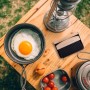 Relaxdays Tischkehrset: Schwarzer Besen mit Holzgriff auf Holztisch, neben Spiegelei und Laterne beim Camping.