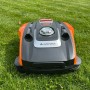 YARD FORCE Mähroboter Compact 300RBS in Orange-Grau auf Rasen. Mit STOP-Taste und Bedienfeld.