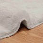 Nahaufnahme eines beigen, runden vidaXL Kunstfell Teppichs Olite aus weichem Polyester auf Holz. Flauschige Textur.