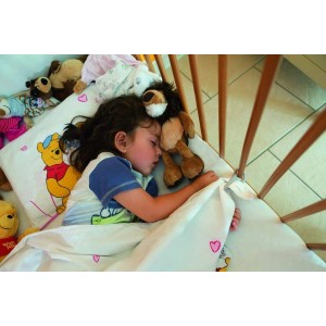 Schlafendes Kind im Gitterbett mit Abus Bettdeckenhalter Janita.