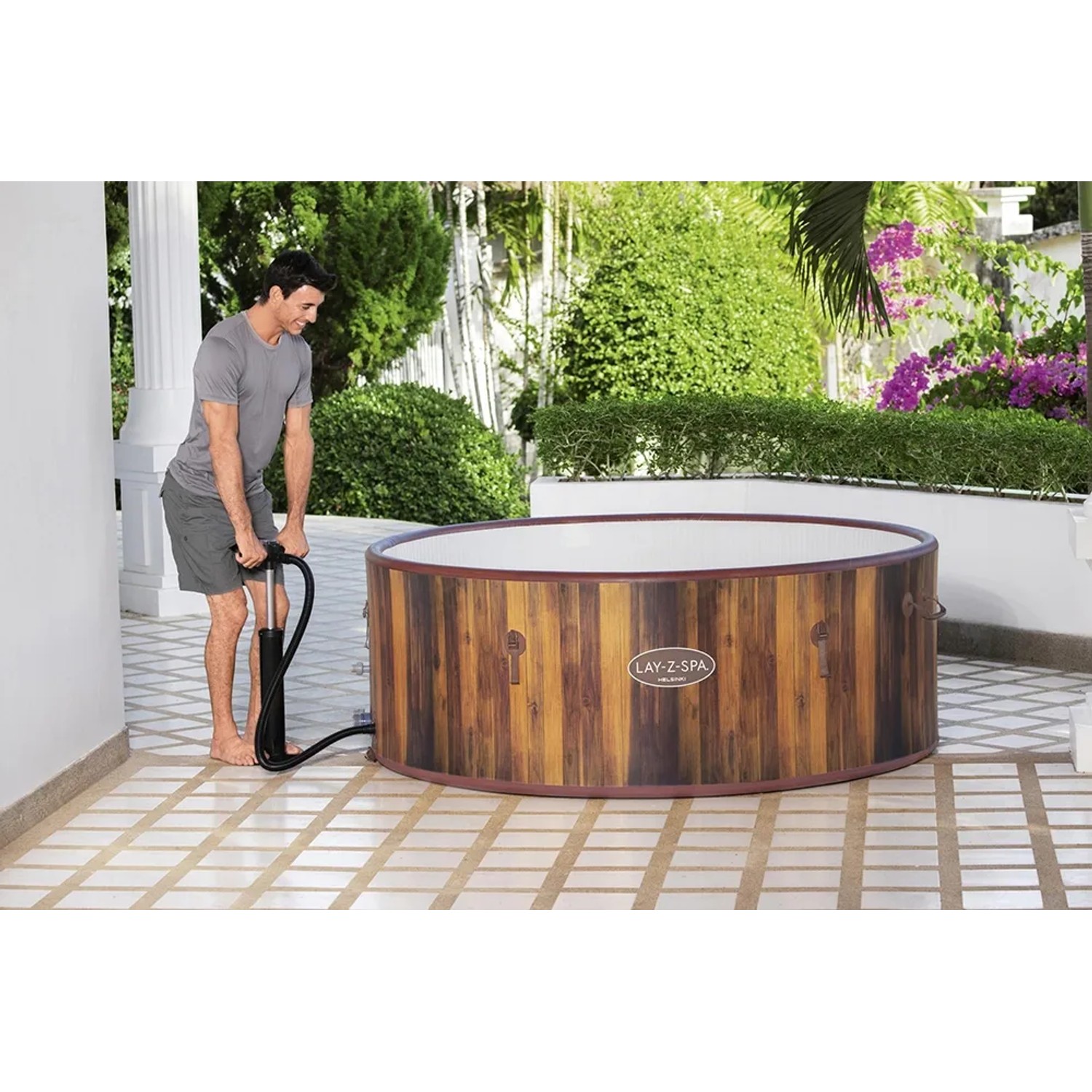 LAY-Z-SPA Helsinki AirJet Whirlpool mit Holzoptik wird mit Handpumpe aufgepumpt.
