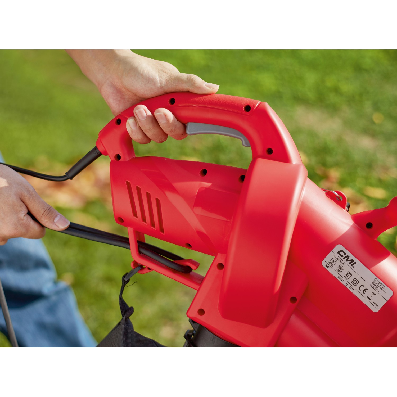 Roter CMI Elektro-Laubsauger 3in1 C-ELS-2500 in Nutzung, Detailaufnahme Hand am Griff.