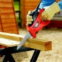 Black+Decker Elektro-Handsäge KS880EC beim Sägen eines Holzstücks auf einer Werkbank.