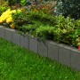 Anthrazitfarbener Rechteck Palisadenrandstein aus Beton als Beeteinfassung im Garten.