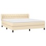 Cremefarbenes Boxspringbett 180x200 cm mit Stoffbezug und gestepptem Kopfteil.