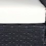 Detailaufnahme: Schwarze Poly-Rattan Lounge-Garnitur mit cremefarbenem Sitzkissen.
