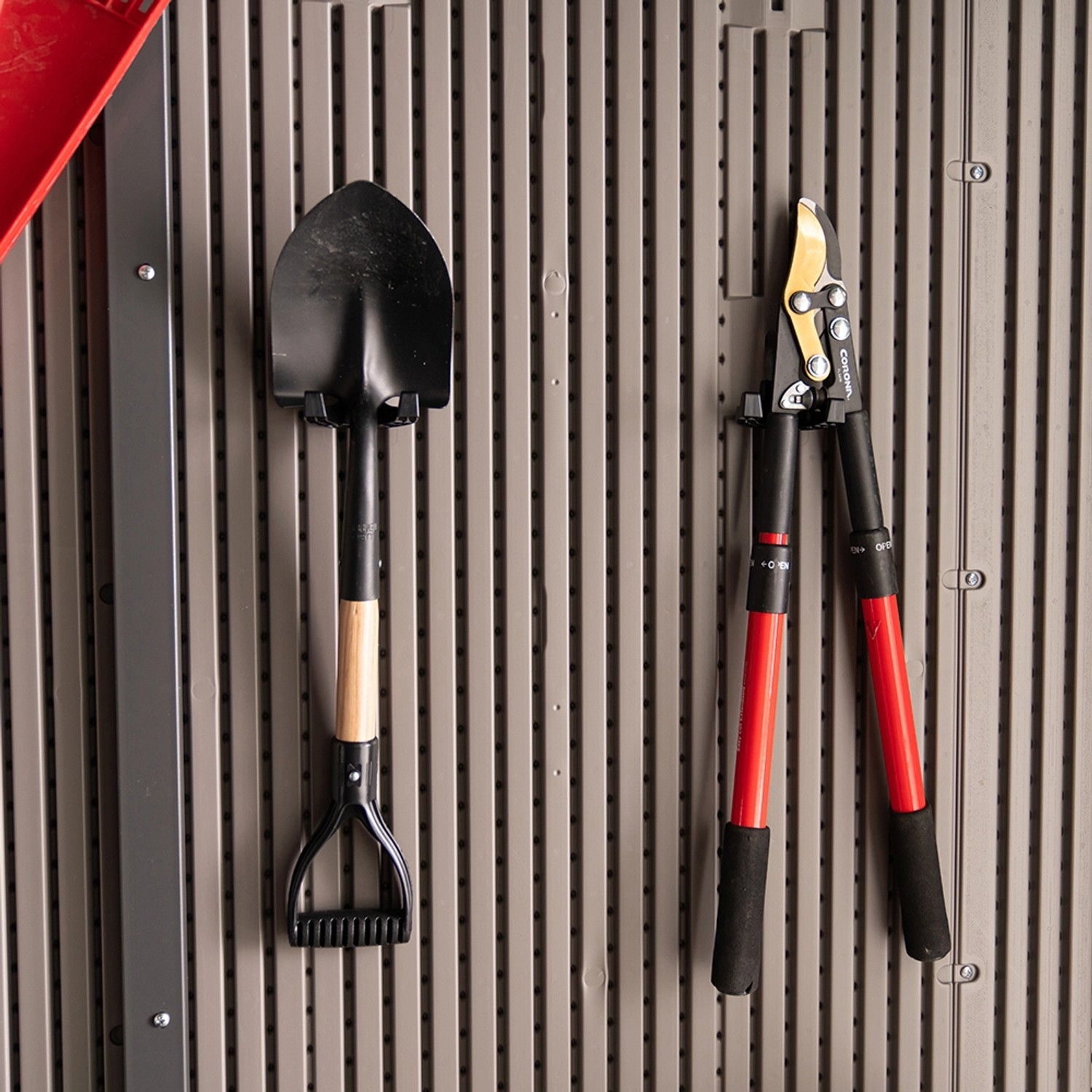 Gartengeräte wie Spaten und Heckenschere hängen im Lifetime Gerätehaus Merkur.