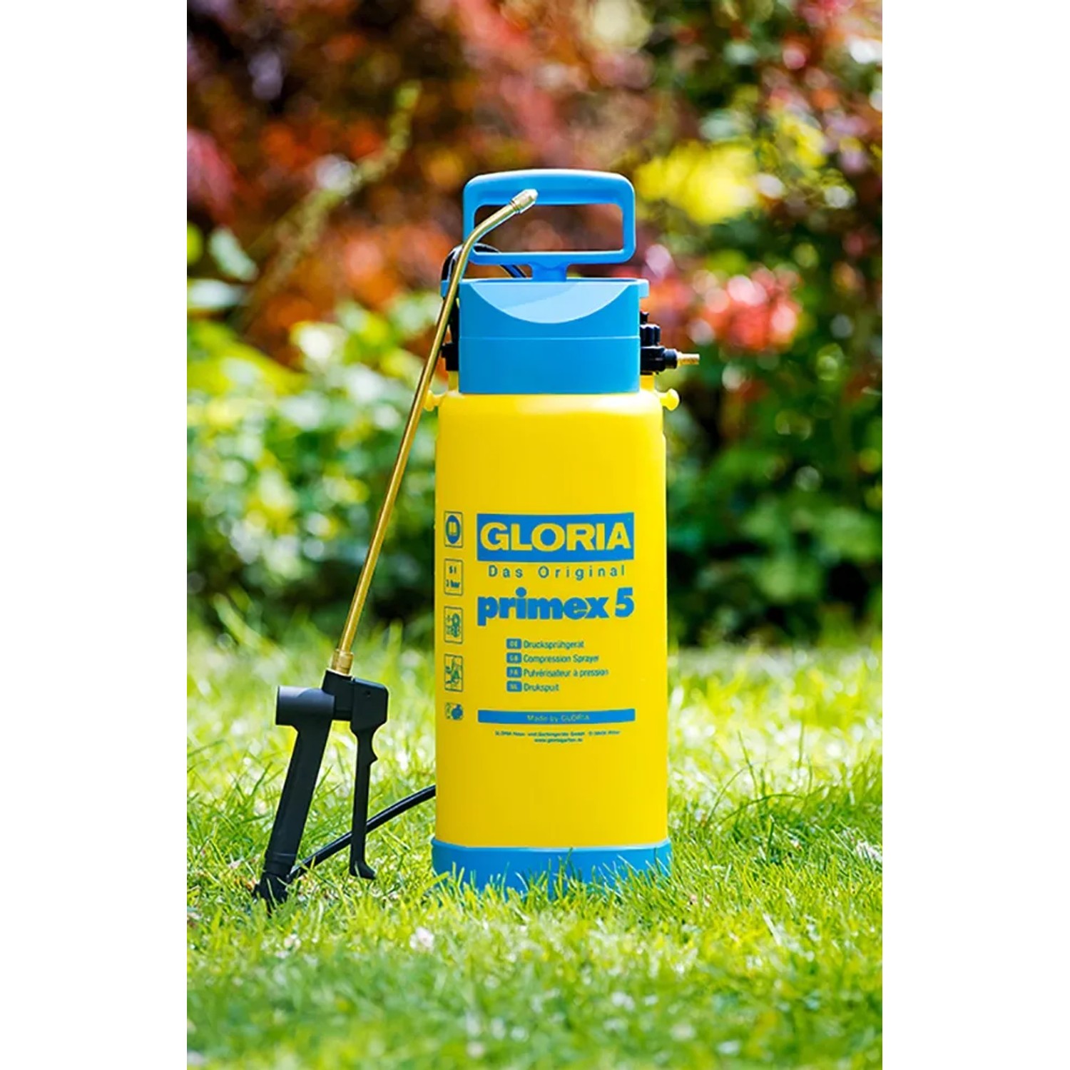 Gelb-blaues Gloria Drucksprühgerät Primex 5 mit Messing-Sprühlanze im Garten.