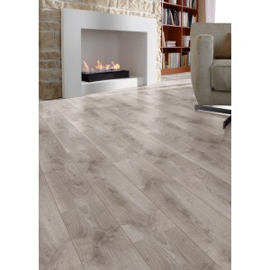 Kaindl Comfort Laminat 7 mm Eiche London mit Holzmaserung in einem modernen Wohnzimmer mit Kamin und Sofa.