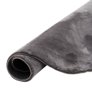Anthrazitfarbener, runder Fellteppich (200x200cm) der Marke Pergamon, zusammengerollt.