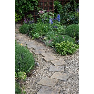 Gartenweg mit Buntkies Rhein (20-40mm) als Zierkies zwischen Steinplatten.