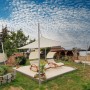 Cremeweißes Toldoro Sonnensegel Dreieck spendet Schatten im Garten. Luftdurchlässig und UV-Schutz.