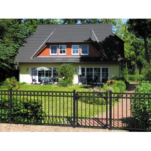 Schwarzes Metallzaun Grund-Set Circle (120x1000 cm) vor einem Haus mit Garten.