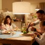 Familie beim Abendessen unter Philips WIZ E27 LED Lampe mit warmweißem Licht.