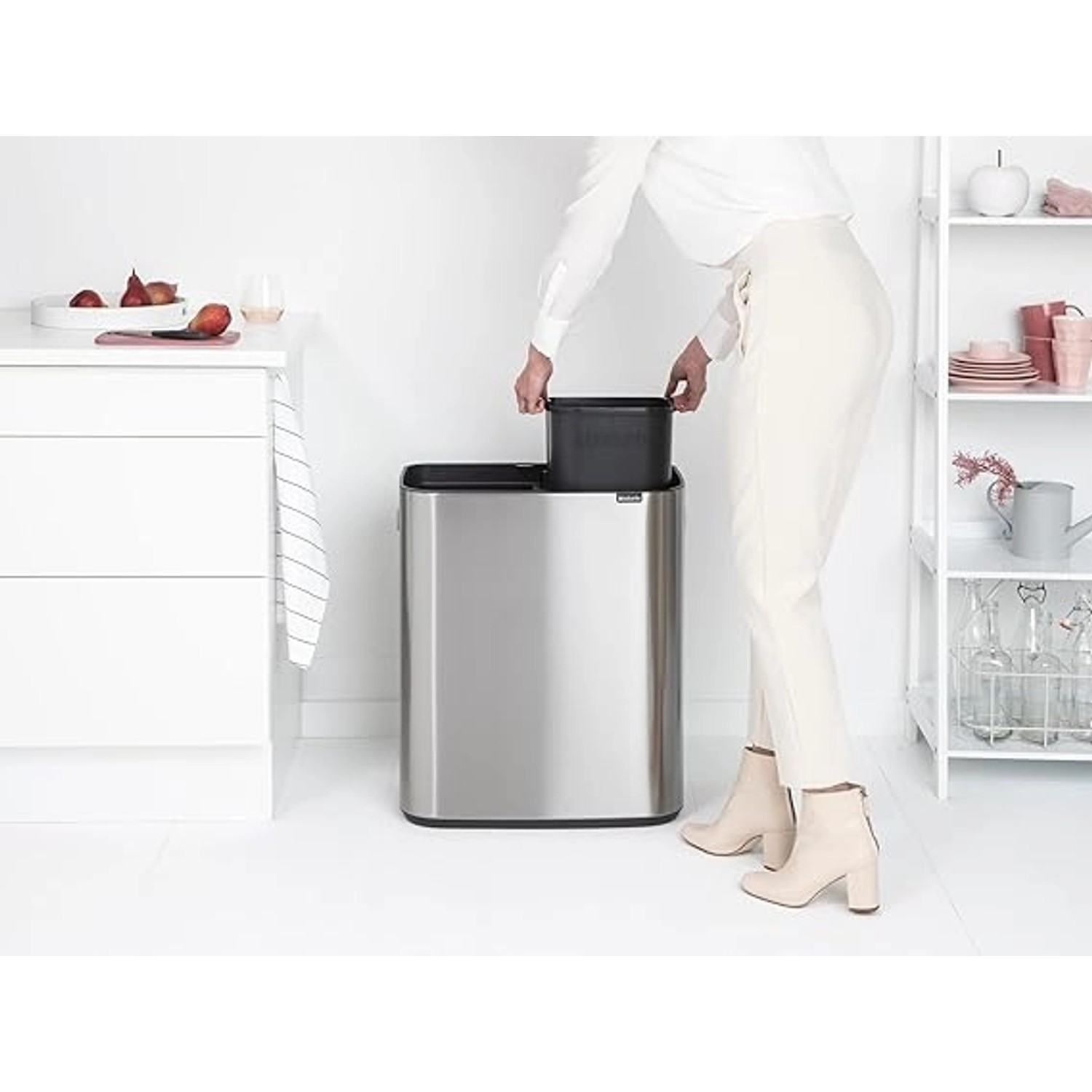 PROREGAL Abfallsammler aus Edelstahl mit zwei Fächern (2x30L) und Touch-Öffnung. Frau entnimmt Inneneimer.