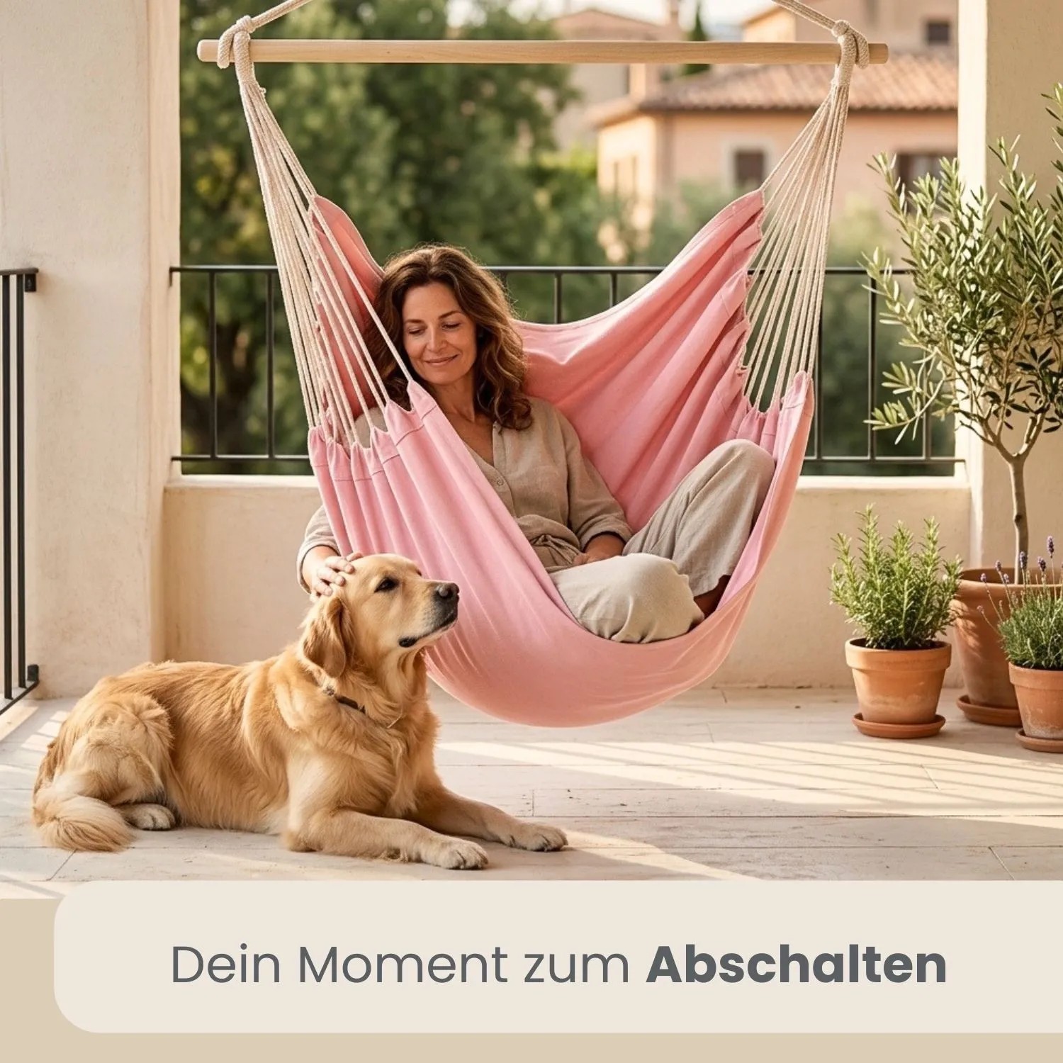 Rosa AMANKA XXL Hängesessel auf Balkon mit entspannter Frau und Hund. Gemütlicher Schwebesessel.
