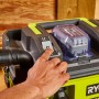 Ryobi Akku-Nass- und Trockensauger RV1811-0 One+ mit Hand beim Einschalten.
