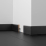 Sockelleiste Esche Weiß, foliert, 56x10x2400 mm, montiert an einer Wand.