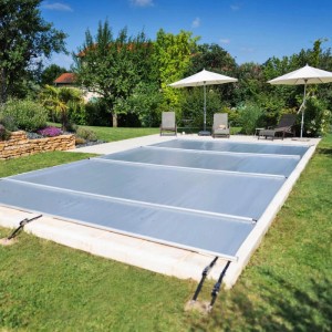Graue CF Poolabdeckung Coverkit 4x9 m aus PVC (580g/m²) für eingelassene Pools im Garten.
