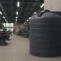 Dunkelgrauer KMND 5000L Trinkwasser Wassertank aus Polyethylen mit Rippen, in Industriehalle. Ideal für Regenwasser.