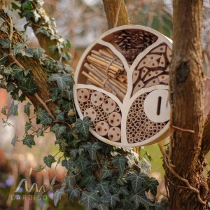 Gardigo Insektenhotel Lebensbaum, rund, aus Holz mit Füllung aus Naturmaterialien, hängt an einem Baum.