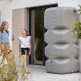 Garantia Gartentank Cubus 1000 l in Betongrau vor Hauswand mit Kindern.
