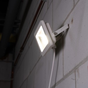 Weißer LED-Außenstrahler (30W) mit Montagewinkel an einer Wand.