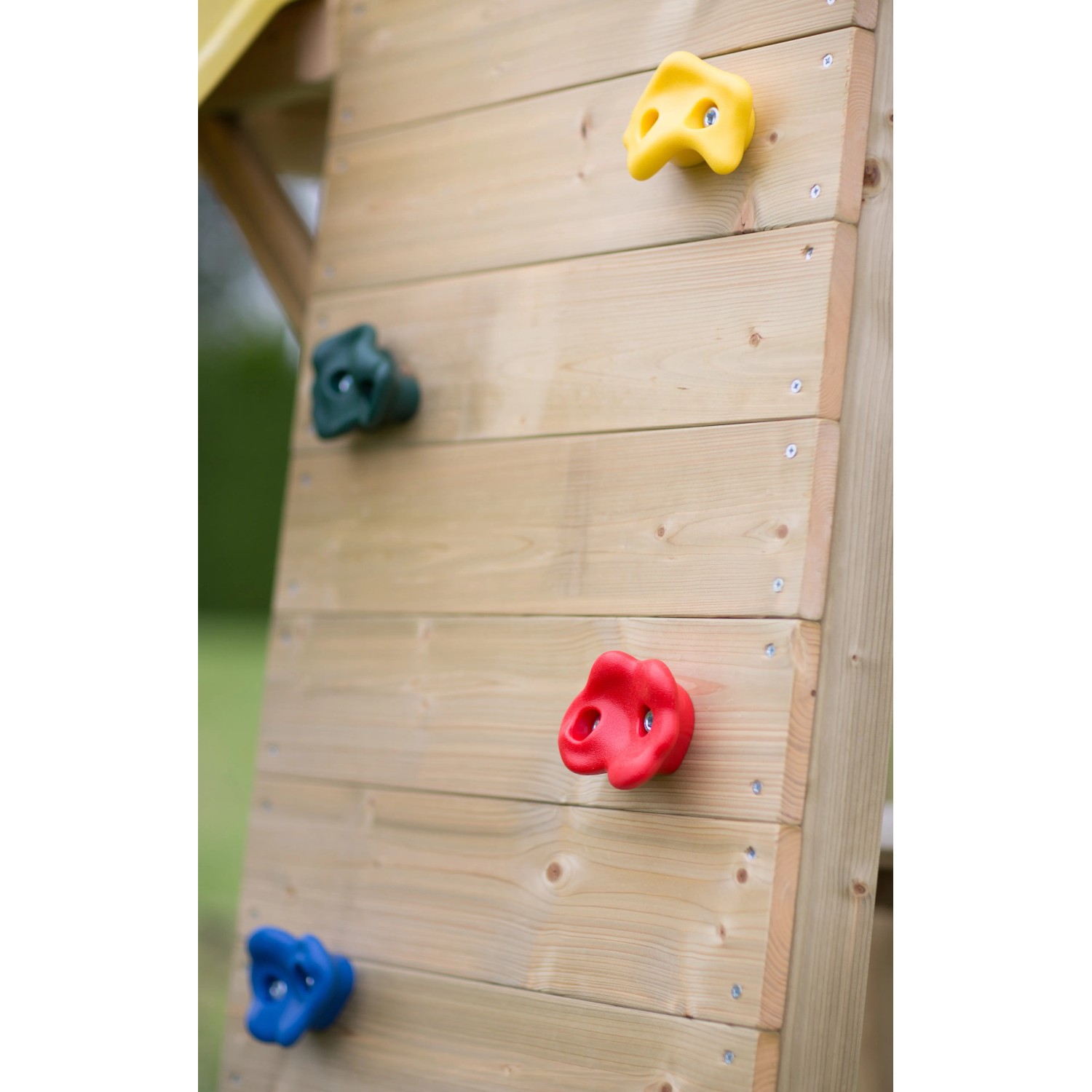 Detailansicht Kletterwand mit bunten Klettersteinen am Kinderspielturm Falke aus Holz.