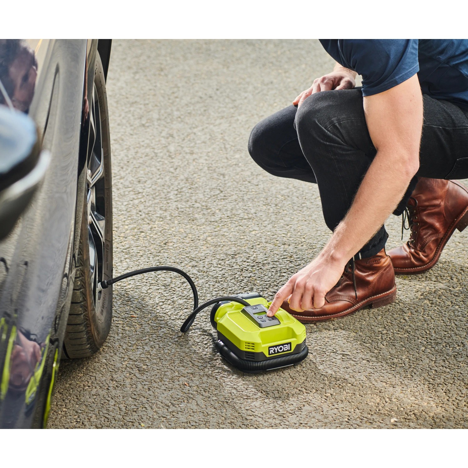 Ryobi Akku-Multi-Kompressor beim Aufpumpen eines Autoreifens. Kompressor mit digitaler Anzeige.