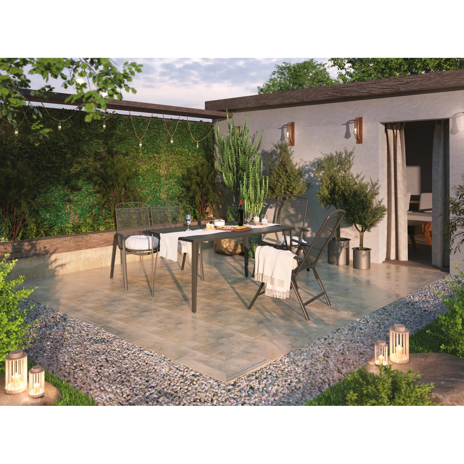 Gartenszene mit Sacramento Stapelstühlen aus Stahlgeflecht und passendem Tisch auf einer Terrasse.
