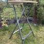 Klappbarer Stehtisch aus Holz und Metall für Garten und Terrasse.