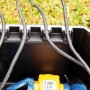 Heissner Garden Power Box: Schwarze Stromverteilerbox mit Kabeln und Stecker im Garten.