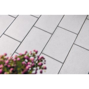 Diephaus Terrassenplatte Nano Tec grau-weiß, 60x40 cm, verlegt mit Blumen im Vordergrund.