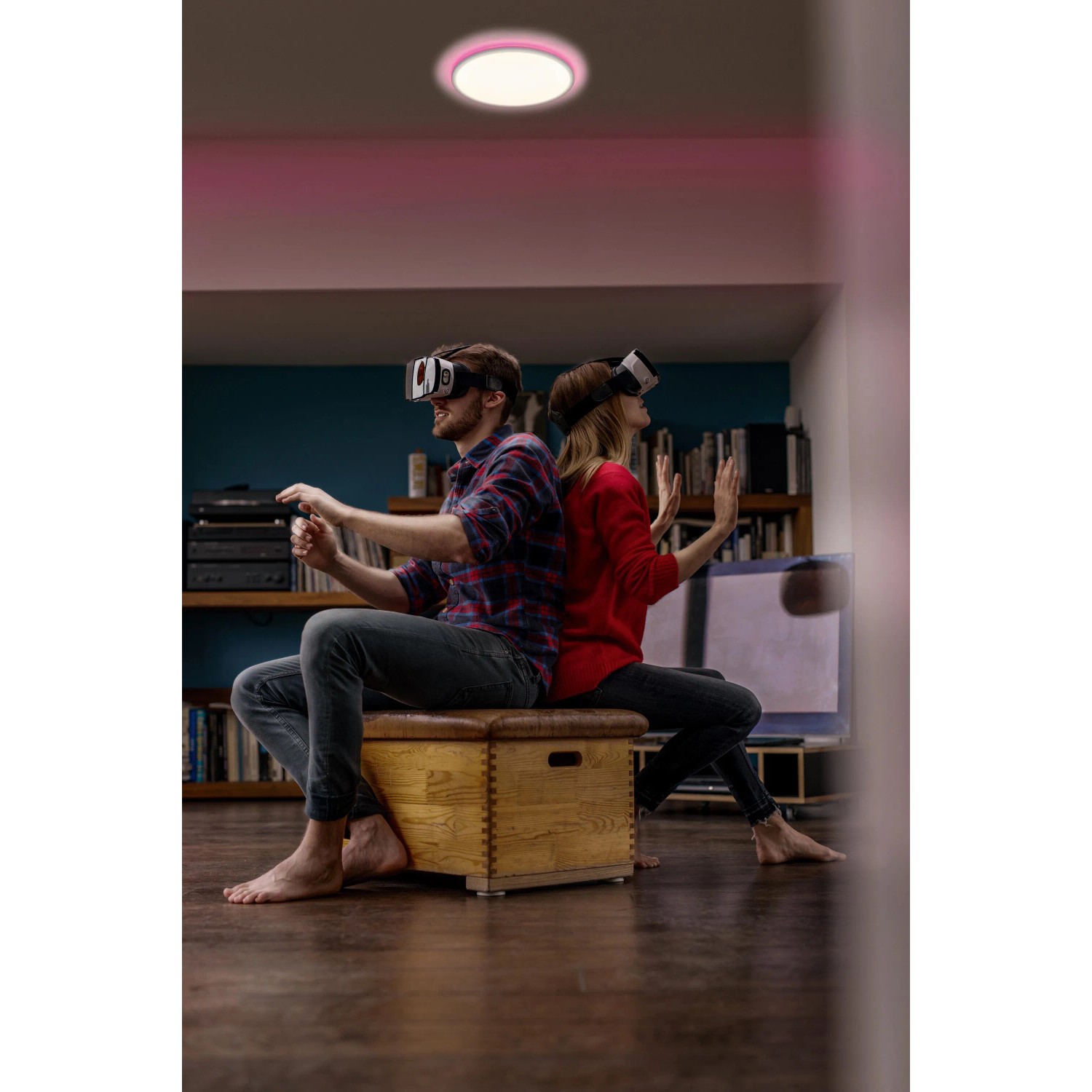 Smarte Ledvance LED Deckenleuchte Orbis Ultra Slim, schwarze Rücklicht, Ø 23 cm, im Wohnzimmer mit zwei Personen.