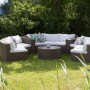 Braunes Beliani Lounge Set SEVERO mit Tisch und cremeweissen Polstern im Garten.