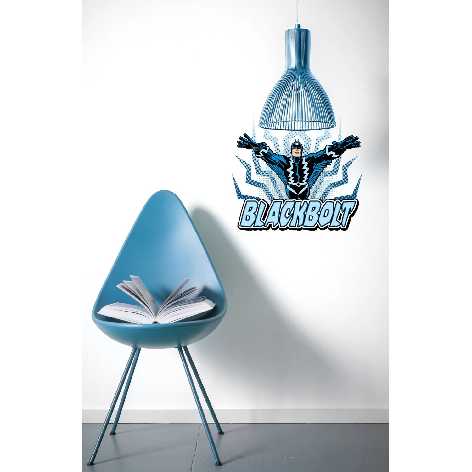 Komar Deko-Sticker Blackbolt Classic an Wand über blauem Stuhl und Lampe.