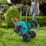 Gardena CleverRoll M Easy Schlauchwagen im Garten, mit Frau und Schlauch. Praktische Schlauchaufbewahrung.
