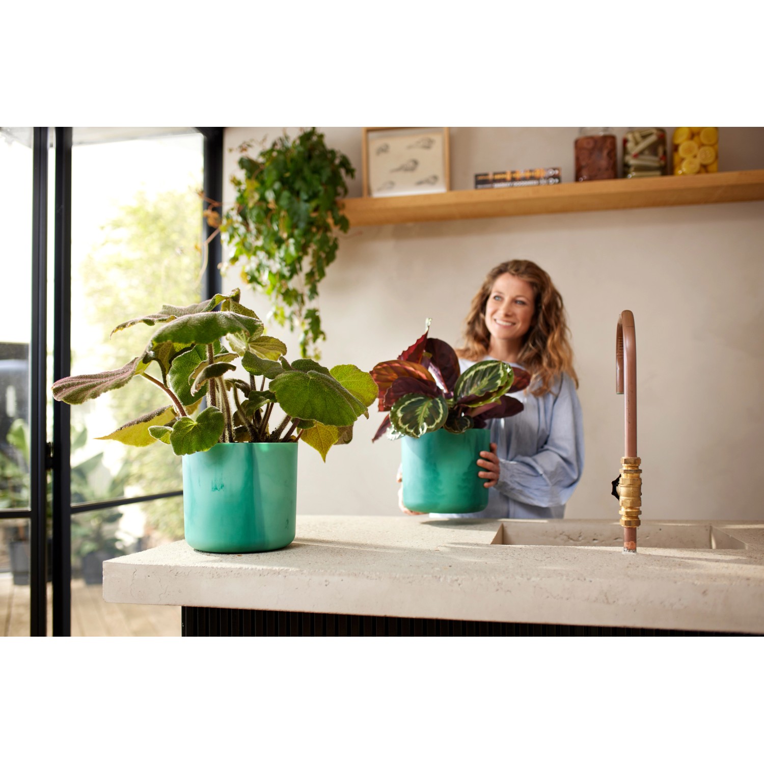 Zwei atlantikblaue Elho Blumentöpfe Ocean Collection (Ø 16 cm) mit Pflanzen in moderner Küche.