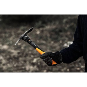 Fiskars Kreuzhacke Pro IsoCore S mit orange-schwarzem Griff in der Hand, geeignet für die Bodenbearbeitung.