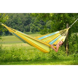 Frau entspannt in gelb-grün gestreifter Amazonas Hängematte Colombiana im Garten.