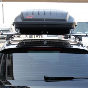 Schwarze, matte Dachbox mit 460 Liter Volumen auf einem Autodach.