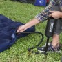 Aufpumpen eines blauen Single-Luftbetts 185x76x22 cm mit einer Luftpumpe im Camping-Einsatz.