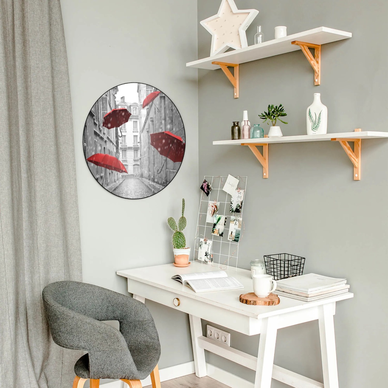 Runde, schwarze Magnettafel mit Motiv 'Rote Schirme' als Wanddekoration im Raum.