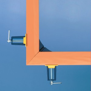 LUX Gehrungszwinge Classic beim Spannen eines orangefarbenen Rahmens im 90-Grad-Winkel.