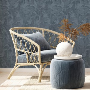 Dunkelblaue Leinen Tapete mit Palmenmuster im Boho-Stil hinter Korbsessel und Hocker.